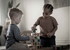 Two children playing with wooden blocks
